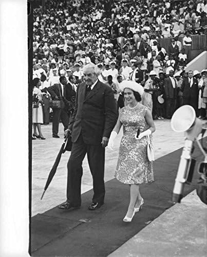 Реколта снимка на принцеса Маргарет, прогуливающейся с мъж по червения килим.